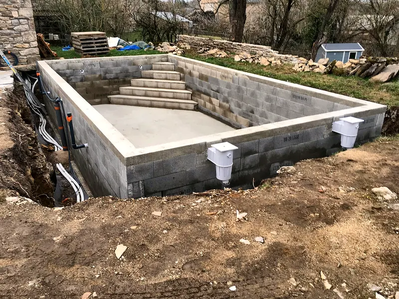 Chantier de construction – Murs en agglo, grand escalier et skimmers en place.