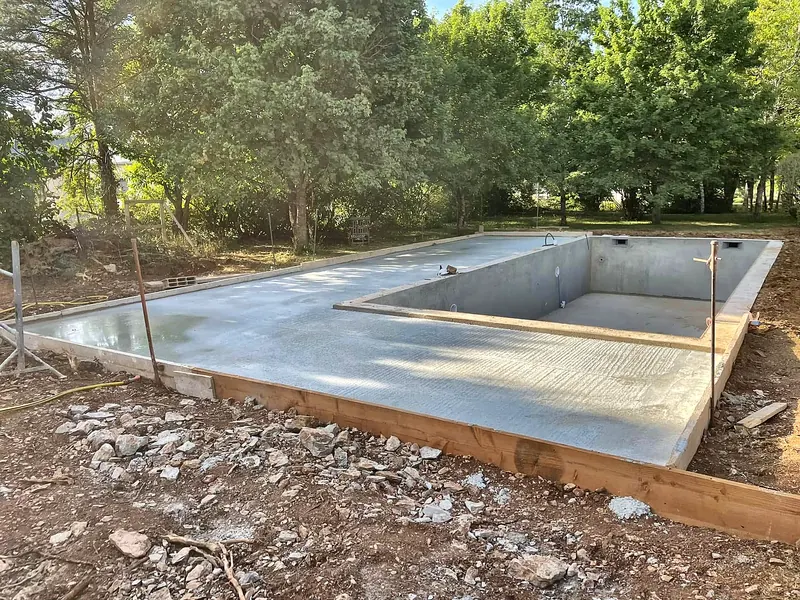 Chantier de construction – Coulage de la dalle de la future plage autour du bassin.