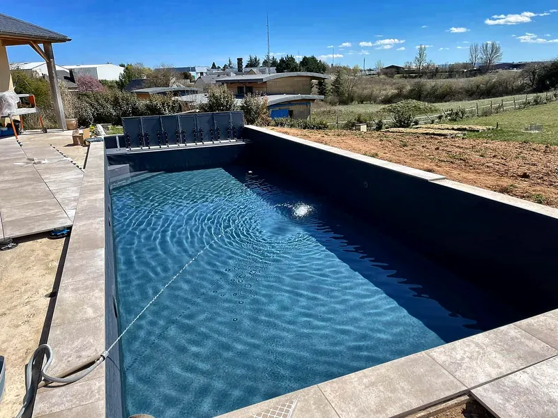 PVC armé – Mise en eau d’un bassin en PVC armé anthracite avec volet immergé.
