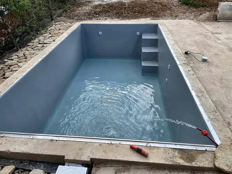 PVC armé – Mise en eau d’un bassin en PVC armé gris clair.